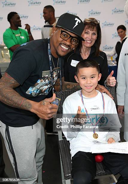 Player Ted Ginn Jr., Linda Daily, Au.D. And patient Jeremiah give a thumbs up after Jeremiah was fitted with a hearing aid at the Starkey Hearing...