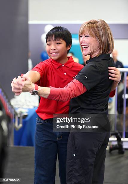 Philanthropist Sandi Young and volunteer Ethan interact during the Starkey Hearing Foundation hearing mission during Super Bowl weekend 2016 at San...