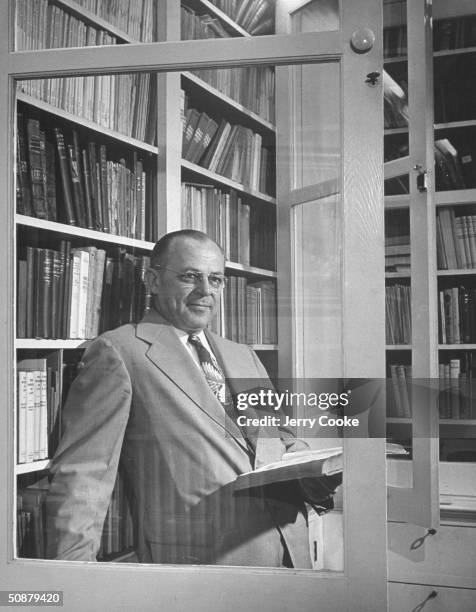 Astrologer Ernest Grant, reading a book in his home library.
