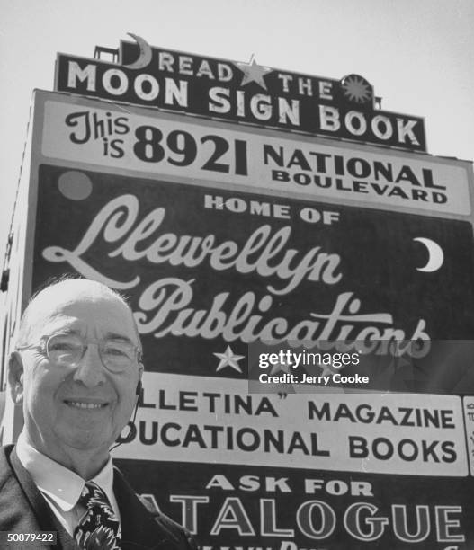 Dr. Llewllyn George, standing in front of a sign advertising his publications.