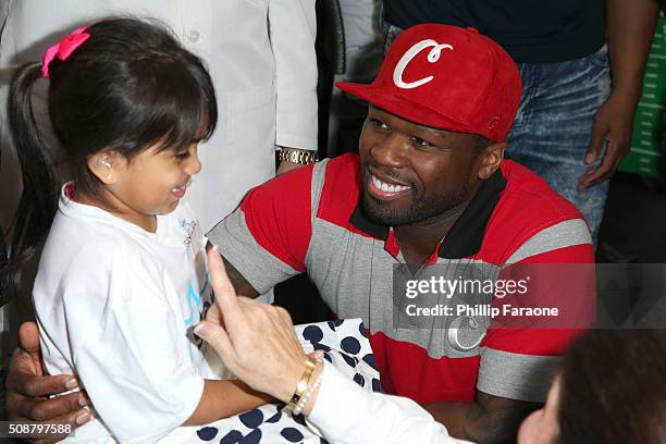 Rapper 50 Cent attends to patient Isabella at the Starkey Hearing Foundation hearing mission during Super Bowl weekend 2016 at San Francisco State...