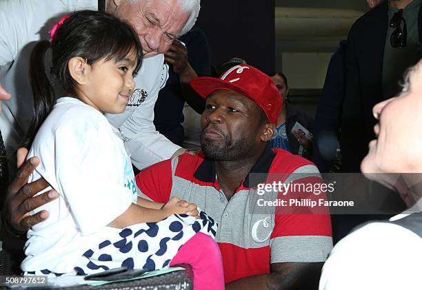 Rapper 50 Cent attends to patient Isabella at the Starkey Hearing Foundation hearing mission during Super Bowl weekend 2016 at San Francisco State...
