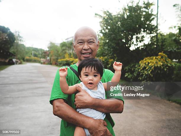 grandpa or granddad holding his grandchild/grandkid (baby) - philippines family stock pictures, royalty-free photos & images