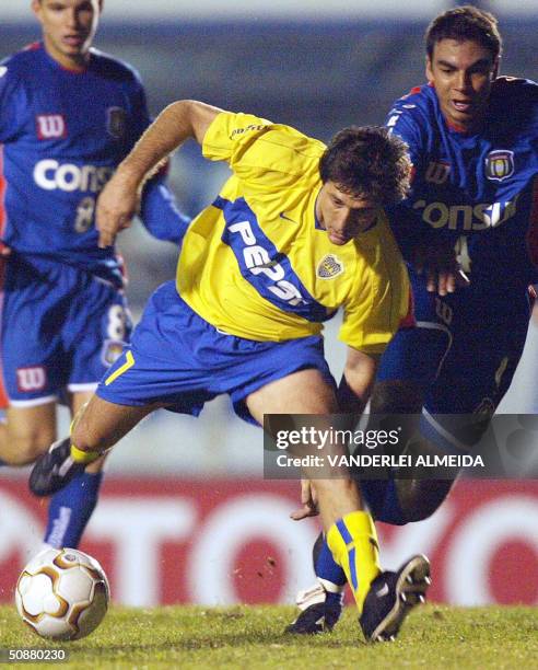 Guillermo Barros Schelotto del equipo argentino de Boca Juniors intenta mantenerse en pie ante la presion de Dininho del equipo brasileno de Sao...