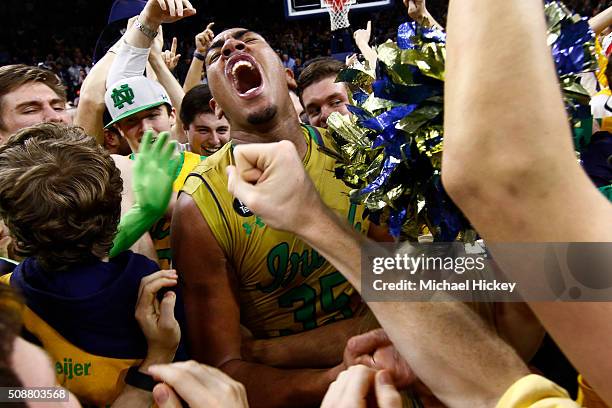 Bonzie Colson of the Notre Dame Fighting Irish celebrates on the court with students after defeating North Carolina Tar Heels at Purcell Pavilion on...