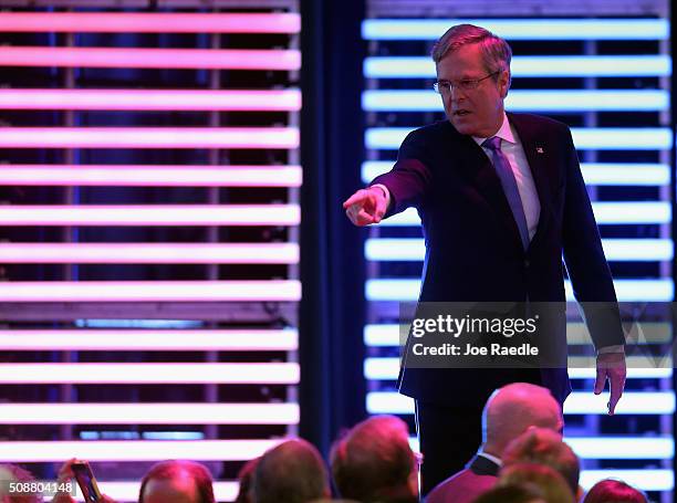 Republican presidential candidate Jeb Bush points toward the audience during a commercial break in the Republican presidential debate at St. Anselm...