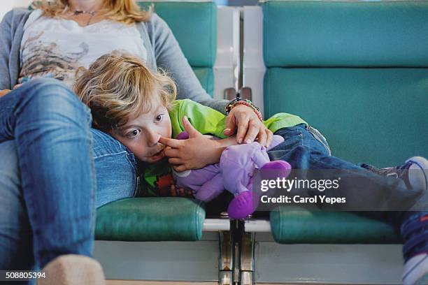 boring boy waiting in airport - picarse la nariz fotografías e imágenes de stock