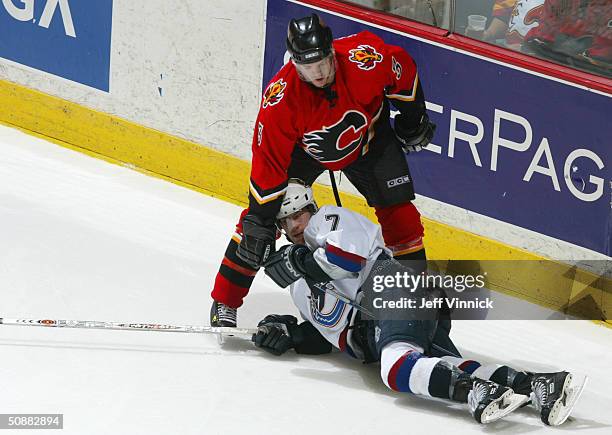 Denis Gauthier of the Calgary Flames defends a fallen Brendan Morrison of the Vancouver Canucks during game four of the first round of the 2004 NHL...