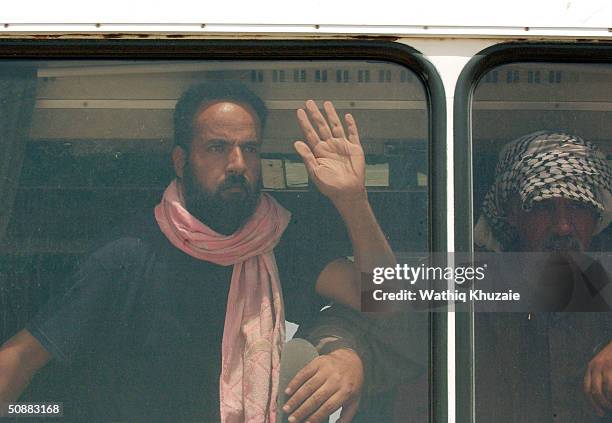 Freed Iraqi prisoner waves from a bus after being released from Abu Ghraib prison May 21, 2004 outside of Baghdad, Iraq. More than 400 prisoners were...