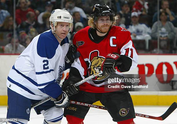 Brian Leetch of the Toronto Maple Leafs vies for position with Daniel Alfredsson of the Ottawa Senators during game four of the Eastern Conference...