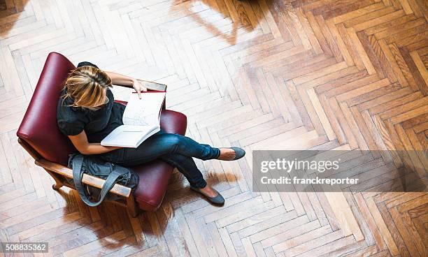 female student reading a book library - college student holding books stockfoto's en -beelden