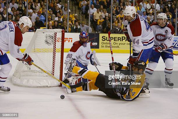 Goalie Jose Theodore of the Montreal Canadiens protects the puck from defender Nick Boynton of the Boston Bruins during game five of the Eastern...