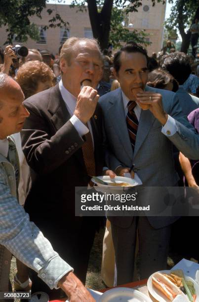 During the election campaign, American President Gerald Ford and his running mate Bob Dole eat hot dogs at a photo opportunity in Dole's hometown,...