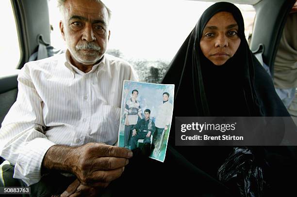 Salma Mahdi Samir sits with a man holding a picture of her son, hoping her son is among the prisoners released from Abu Ghraib prison May 14, 2004 in...