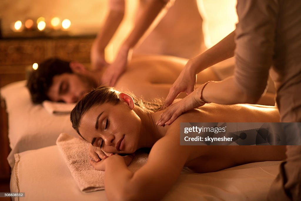 Young couple enjoying at spa during back massage.