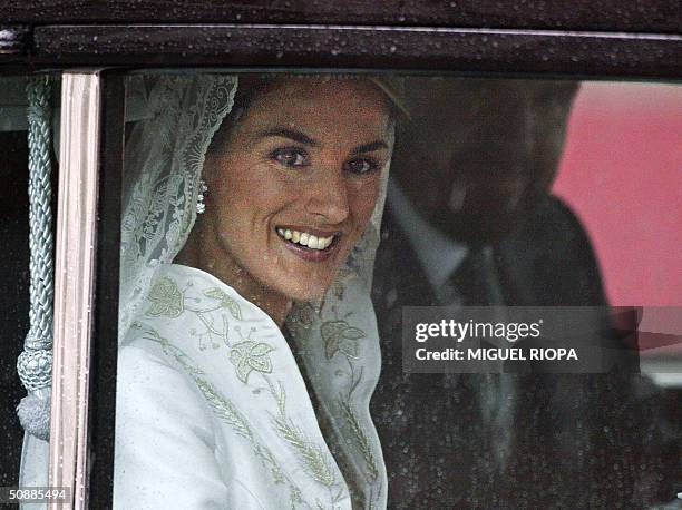 Former journalist Letizia Ortiz smiles to photographers as she arrives at Madrid's Almudena Cathedral with her father Jesus to marry Spanish Crown...