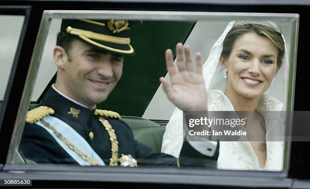 Spanish Crown Prince Felipe de Bourbon and his bride Letizia wave as they leave the Royal Palace May 22, 2004 in Madrid.