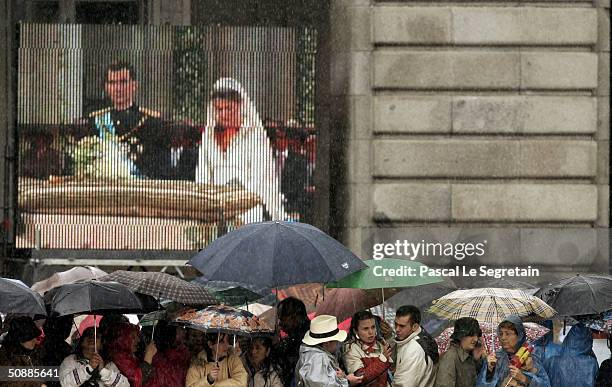 People stand in the rain as they watch the wedding between Spanish Crown Prince Felipe de Bourbon former journalist Letizia Ortiz at the Almudena...