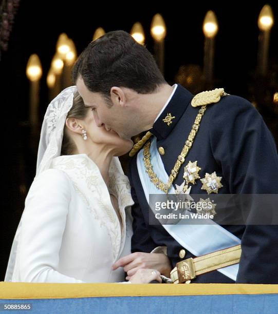 Spanish Crown Prince Felipe de Bourbon and his bride Letizia kiss as the Royal couple appears on the balcony of Royal Palace May 22, 2004 in Madrid.