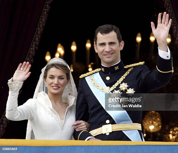 Spanish Crown Prince Felipe de Bourbon and his bride Letizia wave as the Royal couple appears on the balcony of Royal Palace May 22, 2004 in Madrid.