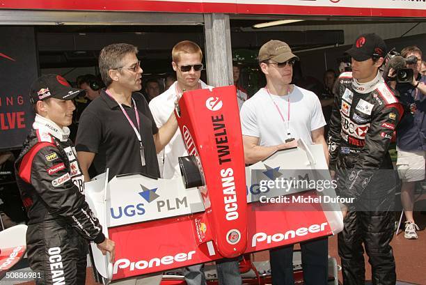 Christian Klein, George Clooney, Brad Pitt, Matt Damon and Mark Webber pose during a guided tour of the Jaguar garage as the official guests of...