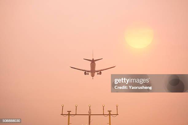 airplane landing at shanghai hongqiao airport. runway lights in the foreground. - live launch arrivals stockfoto's en -beelden