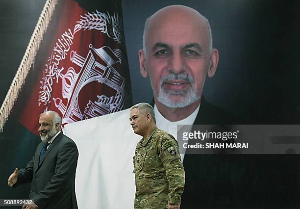 Commander of US and NATO forces in Afghanistan General John F. Campbell and Afghan Acting Defence Minister Masoom Stanekzai walk to attend a joint...
