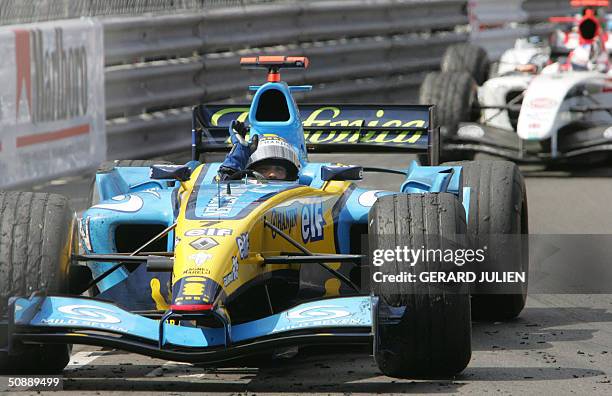 Italian Renault driver Jarno Trulli jubilates as he crosses the finish line ahead of English BAR-Honda driver Jenson Button on the Monte-Carlo...