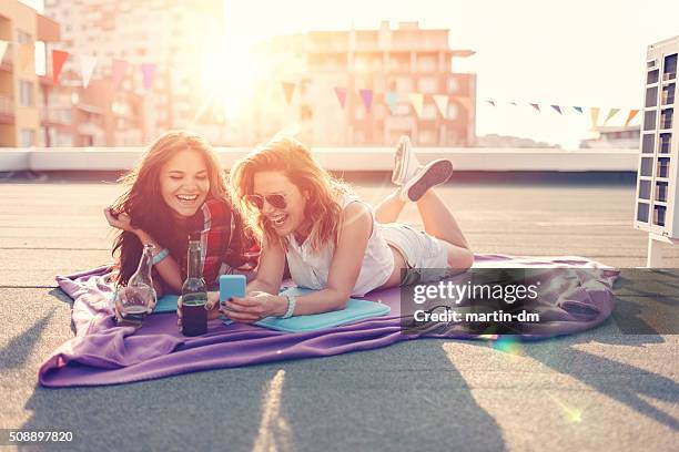 mädchen trinken bier auf dem dach - girls sunbathing stock-fotos und bilder