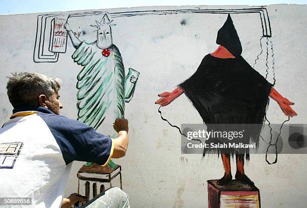 Salaheddin al-Sallat, 30-years-old, an Iraqi artist, makes a wall painting depicting the prisoner abuse in Abu Ghraib prison, on the main street of...