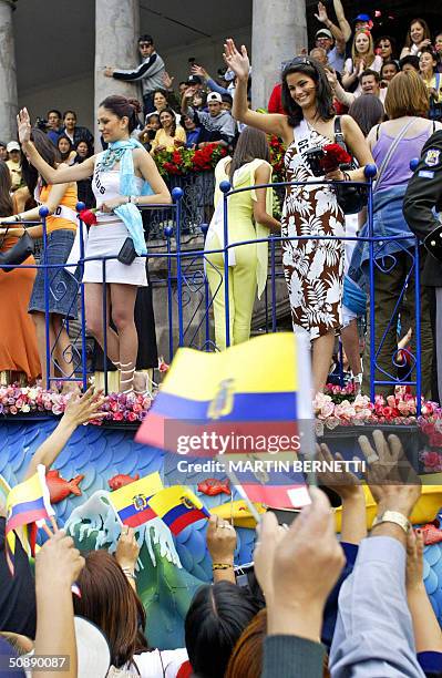 Miss Germany Shermine Sharivar and Miss Cyprus Nayia Iacovidou wave at the crowd during a parade in Quito, Ecuador, 23 May 2004, where the Miss...