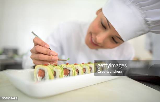 asian woman decorating a plate - sushi chef stock pictures, royalty-free photos & images