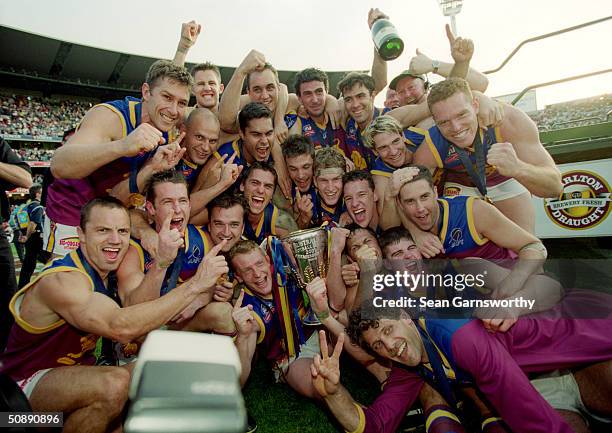 The Brisbane Lions celebrate with the premiership trophy after defeating the Bombers in the 2001 AFL Grand Final played between the Essendon Bombers...