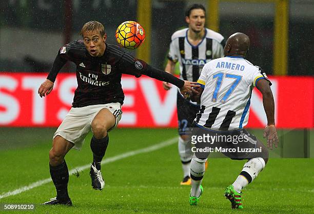 Keisuke Honda of AC Milan competes for the ball with Pablo Armero of Udinese Calcio during the Serie A match between AC Milan and Udinese Calcio at...