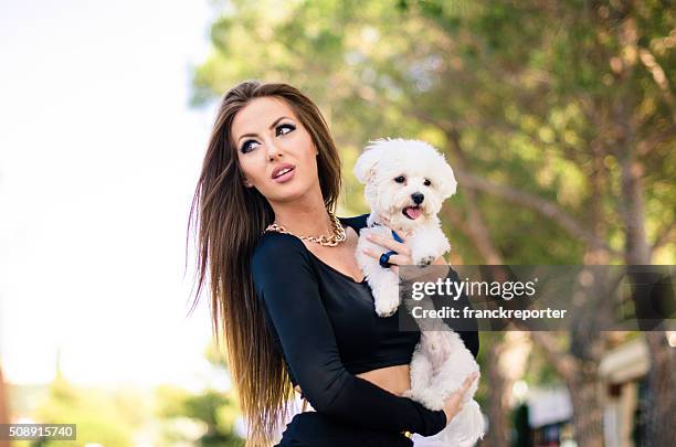 woman embracing her dog on the street - yorkshireterriër stockfoto's en -beelden