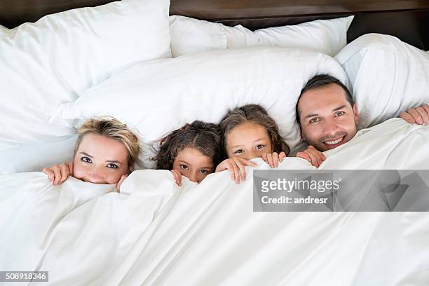 famiglia felice a letto  - piumone foto e immagini stock