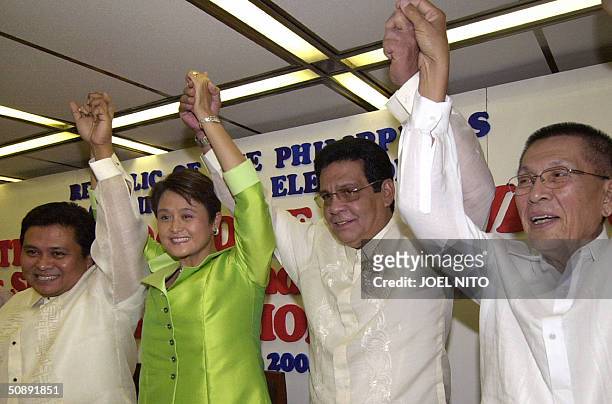 Phillipines cinema actor and opposition presidential candidate Fernando Poe raises the hands of his winning senatorial candidates Jinggoy Estrada,...
