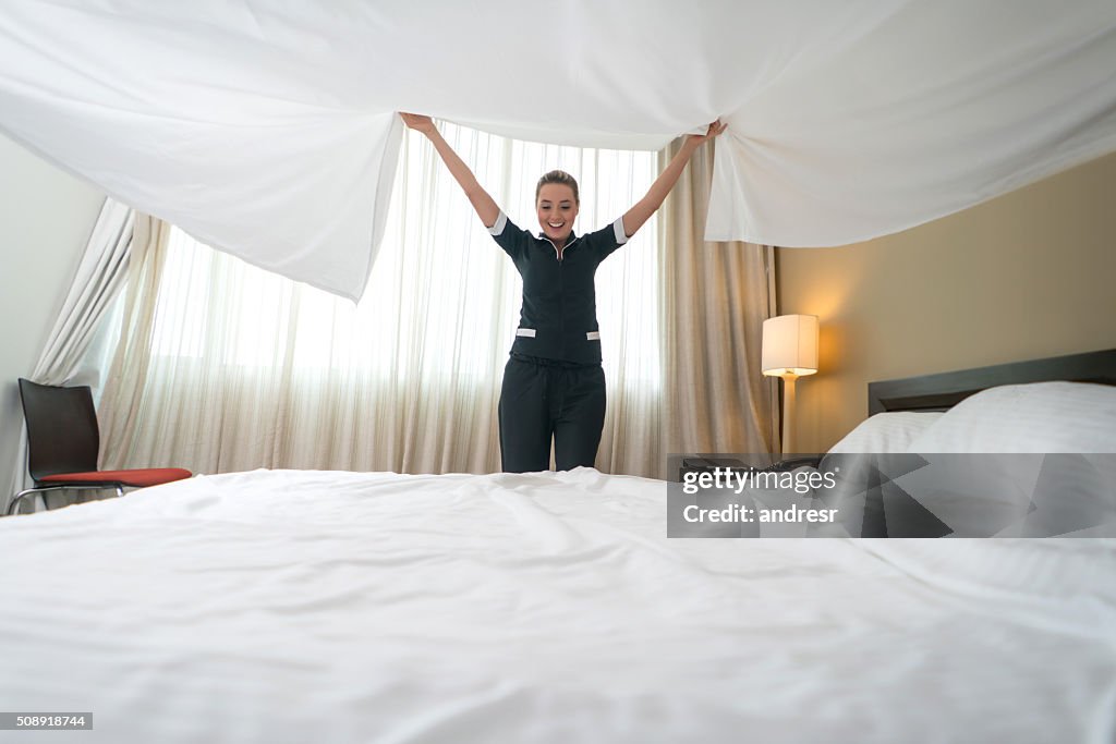 ベッドを作るホテルで働く家政婦