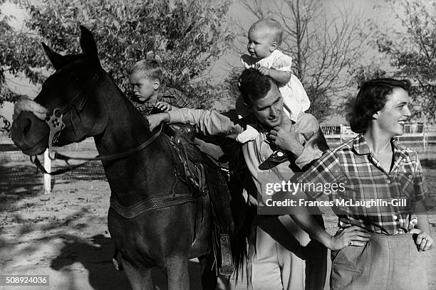 George H. W. Bush with his wife, Barbara, and their children Pauline and George W. On horse in the yard of their Midlands, Texas ranch.