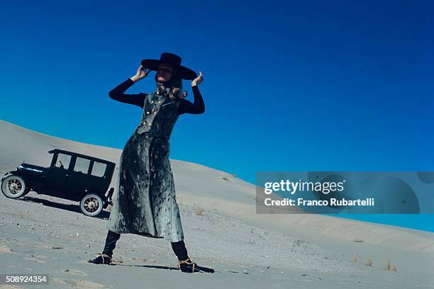 Model Veruschka standing near the Monahans Sandhills, Texas wearing an Alaskan grey hair seal weskit/vest and wrap skirt by Maximilian, wool sweater...