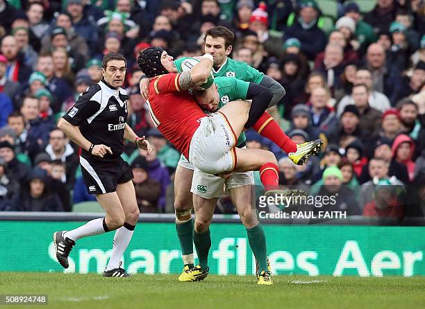 Wales' wing Tom James is tackled by Ireland's wing Keith Earls during the Six Nations international rugby union match between Ireland and Wales at...