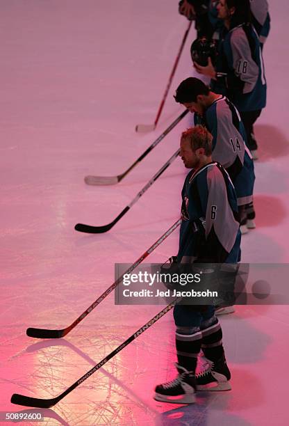 Jason Marshall, Jonathan Cheechoo and Mike Ricci of the San Jose Sharks line up for for the singing of the national anthems prior to taking on the...