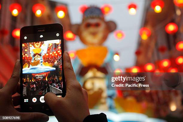 Woman takes pictures of her friends with the Monkey Lantern at a mall in Binondo. Filipinos enjoy Chinese display at Lucky Chinatown in Manila ahead...