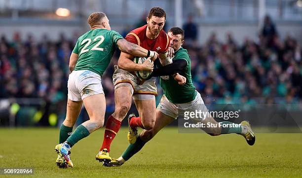 George North of Wales is tackled by Ian Madigan and Robbie Henshaw of Ireland during the RBS Six Nations match between Ireland and Wales at the Aviva...