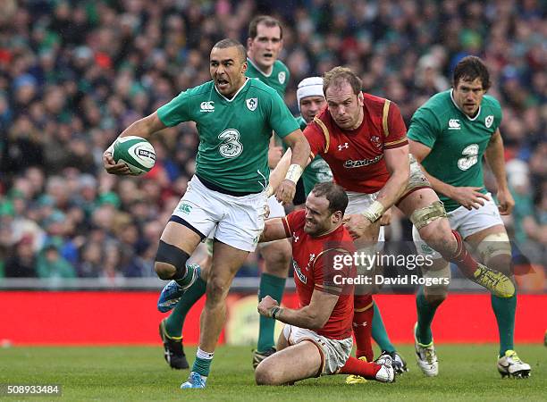 Simon Zebo of Ireland breaks through the tackles from Jamie Roberts and Alun Wyn Jones of Wales during the RBS Six Nations match between Ireland and...