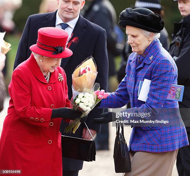 Queen Elizabeth II hands flowers she received from members of the public to her lady in waiting Mary Morrison after attending Sunday service at the...