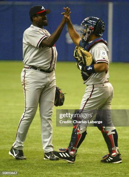 Johnny Estrada of the Atlanta Braves and teammate Antonio Alfonseca celebrate after recording the final out in the Braves' 5-0 win against the...