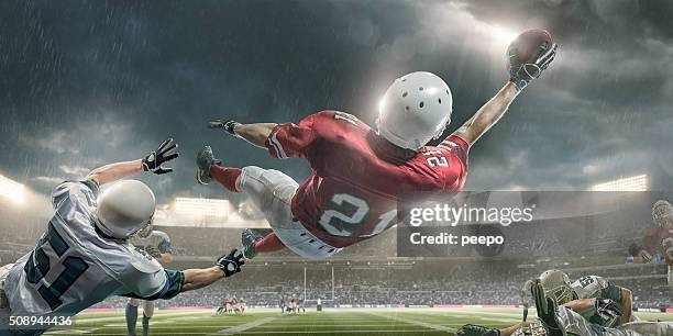 american football player in heroic backwards dive to catch ball - football glove stock pictures, royalty-free photos & images