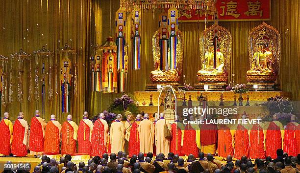 Dozens of orange-robed Buddhist devotees line up to conduct a welcoming ceremony for one of the most important relics in Buddhism, a fragment of bone...