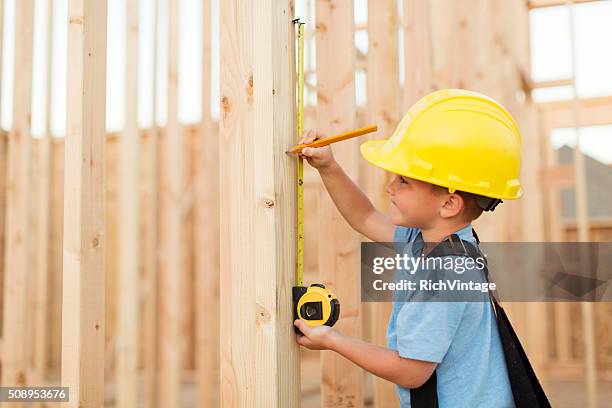 young boy dressed as carpenter with tape measure - boy in hard hat stock pictures, royalty-free photos & images